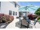 Outdoor patio area features a dining set with umbrella, a screened-in porch, and meticulous landscaping at 12093 Ashland Dr, Fishers, IN 46037