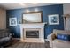 Close-up of a fireplace with a white mantel, framed mirror, and comfortable seating nearby at 12093 Ashland Dr, Fishers, IN 46037