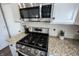 Close up view of the stainless steel stove with granite countertops and backsplash at 12093 Ashland Dr, Fishers, IN 46037