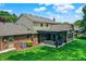 Expansive backyard featuring a covered patio, lush lawn, and attractive landscaping at 1219 Driftwood Dr, Carmel, IN 46033