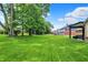 Expansive backyard featuring lush lawn, mature trees, and a covered patio area perfect for entertaining at 1219 Driftwood Dr, Carmel, IN 46033
