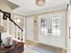 Bright foyer with a staircase, decorative lighting, and elegant double doors leading to the outside at 1219 Driftwood Dr, Carmel, IN 46033