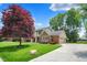 Inviting front of home featuring brick accents, landscaped yard, and a spacious driveway at 1219 Driftwood Dr, Carmel, IN 46033
