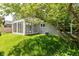 View of the backyard featuring a sunroom addition and healthy, green grass at 12289 Charing Cross Rd, Carmel, IN 46033