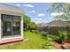 View of a landscaped backyard with a well-maintained lawn and a partial view of the sunroom at 12289 Charing Cross Rd, Carmel, IN 46033