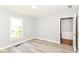 A serene bedroom features a sun-filled window and modern wood-look flooring at 12289 Charing Cross Rd, Carmel, IN 46033