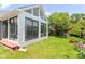 Bright sunroom featuring large windows, vaulted ceiling, and backyard access to lush green lawn at 12289 Charing Cross Rd, Carmel, IN 46033