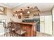 Basement bar area featuring counter seating, shelving for glassware and liquor, and a classic mini-fridge at 13017 Water Ridge Dr, McCordsville, IN 46055