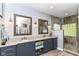 Bathroom featuring double sinks, framed mirrors, and a glass shower with unique stone flooring at 13017 Water Ridge Dr, McCordsville, IN 46055