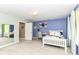 Bright bedroom with a white bed frame, a dedicated study area, and natural light from a large window at 13017 Water Ridge Dr, McCordsville, IN 46055