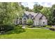Beautiful two-story home with a well-manicured lawn, mature trees, and striking architectural details at 13017 Water Ridge Dr, McCordsville, IN 46055