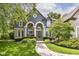 Charming blue home showcasing arched windows, white pillars, and professional landscaping in the front yard at 13017 Water Ridge Dr, McCordsville, IN 46055