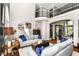Open living area with vaulted ceiling, comfortable seating, hardwood floors, and large windows providing natural light at 13017 Water Ridge Dr, McCordsville, IN 46055