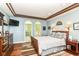Bedroom with tray ceilings, hardwood floors, and a view of the yard through arched windows at 13017 Water Ridge Dr, McCordsville, IN 46055