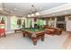 Spacious recreation room with a pool table, comfortable seating, a fireplace, and natural light at 13017 Water Ridge Dr, McCordsville, IN 46055