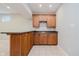 Basement bar area features wooden cabinets, countertop seating, sink, and tile flooring, perfect for entertaining at 13896 Fernleaf Way, Carmel, IN 46033