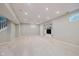 Spacious finished basement with recessed lighting, neutral carpet and paint, and built-in shelving with a television at 13896 Fernleaf Way, Carmel, IN 46033