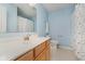 Bright bathroom featuring a wooden vanity, sink, toilet, and a shower with a patterned curtain at 13896 Fernleaf Way, Carmel, IN 46033