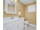 Well-lit bathroom features a white vanity, toilet, mirror, and neutral walls and flooring for a clean look at 13896 Fernleaf Way, Carmel, IN 46033