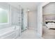 Bright bathroom showcasing a soaking tub, glass shower, and large window at 13896 Fernleaf Way, Carmel, IN 46033