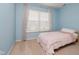 Cozy bedroom with light blue walls, carpet flooring, and a large window at 13896 Fernleaf Way, Carmel, IN 46033