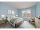 Comfortable bedroom with light blue walls and a window, creating a serene atmosphere at 13896 Fernleaf Way, Carmel, IN 46033