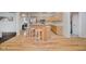 Well-lit kitchen with stainless appliances, light wood cabinetry, and a three-stool breakfast bar at 13896 Fernleaf Way, Carmel, IN 46033