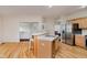 Bright kitchen featuring stainless steel appliances, a breakfast bar, and wood floors at 13896 Fernleaf Way, Carmel, IN 46033