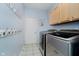 Functional laundry room with modern washer and dryer, cabinets, and a convenient coat rack at 13896 Fernleaf Way, Carmel, IN 46033