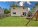 A large backyard features a well-maintained lawn, a patio with table set, and a swing set at 1452 Brookside N Ct, Columbus, IN 47201