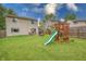 Spacious backyard with play set and lush green grass, surrounded by a wooden fence at 1452 Brookside N Ct, Columbus, IN 47201