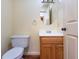 A half bath featuring a wooden cabinet, round mirror, and standard toilet at 1452 Brookside N Ct, Columbus, IN 47201