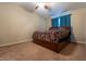 Primary bedroom with a ceiling fan, carpeted floors, and window with curtains at 1452 Brookside N Ct, Columbus, IN 47201