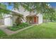 Charming two-story home featuring a well-manicured lawn, rose bushes, and a bright red front door at 1452 Brookside N Ct, Columbus, IN 47201