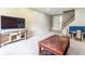 Neutral carpeted living room with tv, wood table and access to stairs at 1452 Brookside N Ct, Columbus, IN 47201