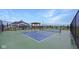 Outdoor pickleball court with a pergola, net, and fenced perimeter with community house in background at 14877 Higgins Dr, Westfield, IN 46074