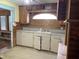 Dated kitchen with wood paneling, white cabinets, and an arched window above the sink at 1546 Wade St, Indianapolis, IN 46203