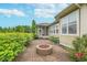 Backyard brick patio featuring a fire pit, complemented by verdant landscaping and a screened-in porch at 16071 Prince Ct, Noblesville, IN 46062