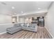 Cozy finished basement with gray L-shaped couch, wood flooring, and a wet bar at 16071 Prince Ct, Noblesville, IN 46062