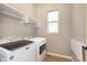 Laundry room with modern washer and dryer, hanging rack, storage and natural light from window at 16071 Prince Ct, Noblesville, IN 46062