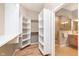 Well-organized walk-in closet featuring built-in shelving and access to the bathroom with a shower at 16071 Prince Ct, Noblesville, IN 46062