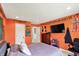 Lively bedroom featuring sports memorabilia, orange walls, and a mounted TV at 16316 Brookhollow Dr, Westfield, IN 46074