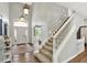 Grand foyer with a staircase and large arched entryway, highlighted by hardwood floors and light fixtures at 16316 Brookhollow Dr, Westfield, IN 46074