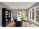 A home office featuring a large black desk, comfortable chairs, a bookshelf, and a window with natural light at 16316 Brookhollow Dr, Westfield, IN 46074