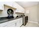 Functional laundry room featuring stylish cabinetry, dark countertop, and modern washer and dryer at 18763 Abigail Cir, Westfield, IN 46062