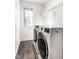 Well-lit laundry room with new washer and dryer and dark wood-look laminate flooring at 197 Ceejay Dr, Greenwood, IN 46142