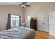 Comfortable bedroom featuring hardwood floors, a ceiling fan, and a view of the en-suite bathroom at 2075 Rhettsbury St, Carmel, IN 46032
