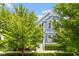 Front exterior of a two-story blue home with white trim and a well-maintained lawn, partially obscured by tree foliage at 2075 Rhettsbury St, Carmel, IN 46032
