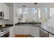 Open kitchen featuring modern appliances, a sink, and a view of the well-lit living room at 2075 Rhettsbury St, Carmel, IN 46032