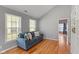 Bright living room with hardwood floors, a comfortable sofa, and natural light from large windows at 2075 Rhettsbury St, Carmel, IN 46032